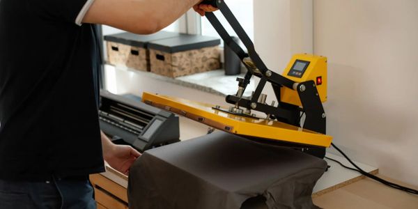 Gentleman pressing a t-shirt on a heat press getting it ready for a custom banana boo dtf transfer. 