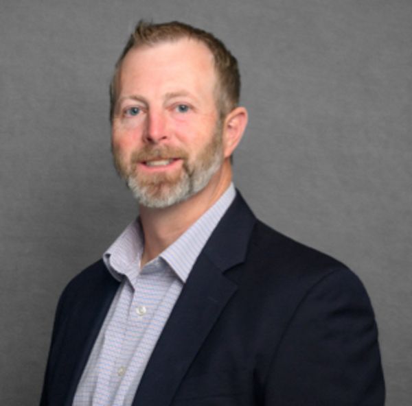 Professional man in suit jacket smiling at camera.