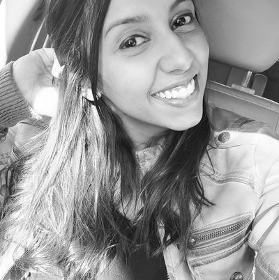 Black and white selfie of a smiling woman in a car.