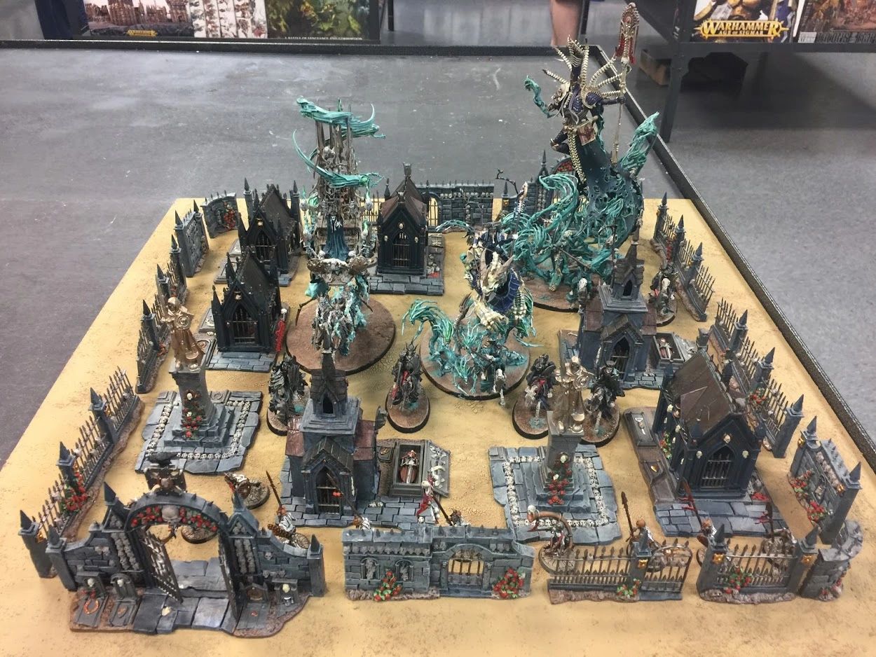 Intricately painted Warhammer graveyard terrain with spectral miniatures and gothic tombs.