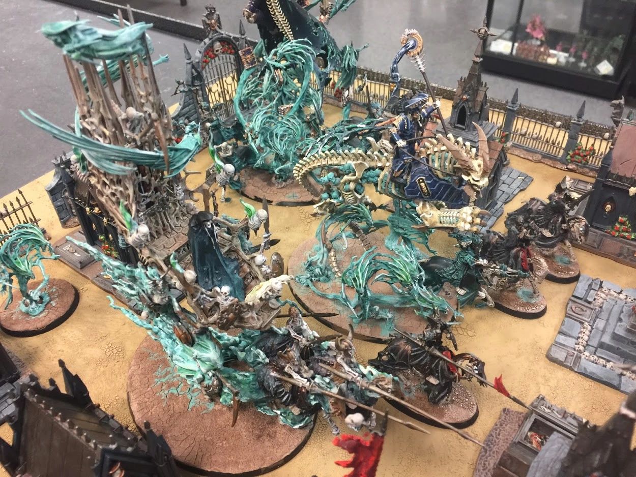Intricately painted Warhammer fantasy miniatures in a detailed battlefield diorama.