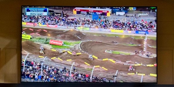 Monster Energy Supercross race with multiple riders on a dirt track.