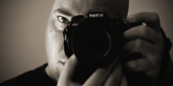 Close-up of a person taking a photo with a camera.