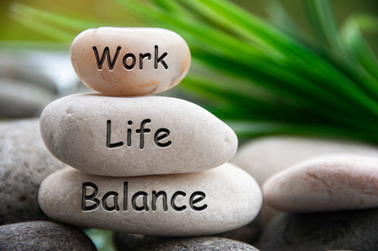 Image of three stones with the words Work, Life, Balance engraved on each stone.