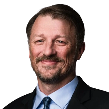 Smiling man in suit and tie with a beard.