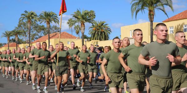 Military recruits running in formation during training.