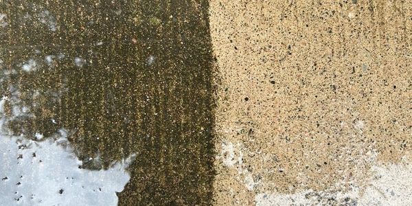 Side-by-side comparison of a dirty and clean concrete surface.