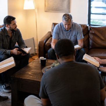 Group of men reading books together.