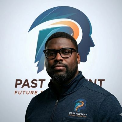 Man wearing glasses stands before a logo for Past Present Future Foundation.