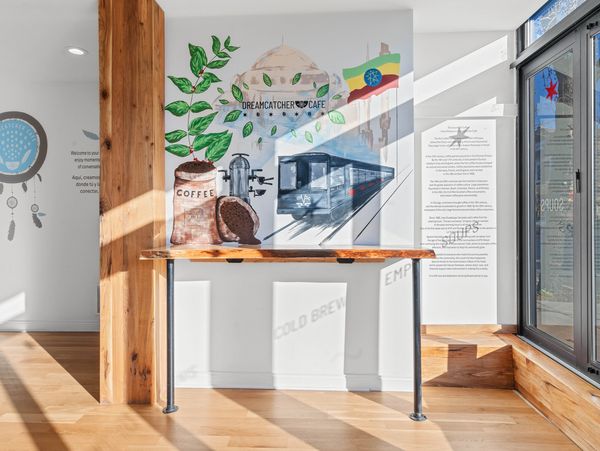 Bright cafe corner with coffee-themed wall art and sunlight streaming in.