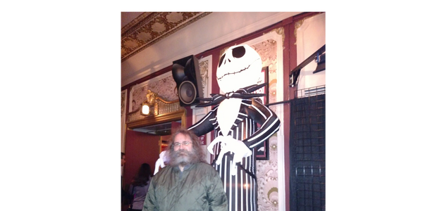 Closeup shot of a man posing for a picture at the halloween decor