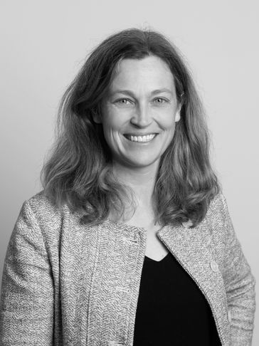 Black and white portrait of a smiling woman with shoulder-length hair.