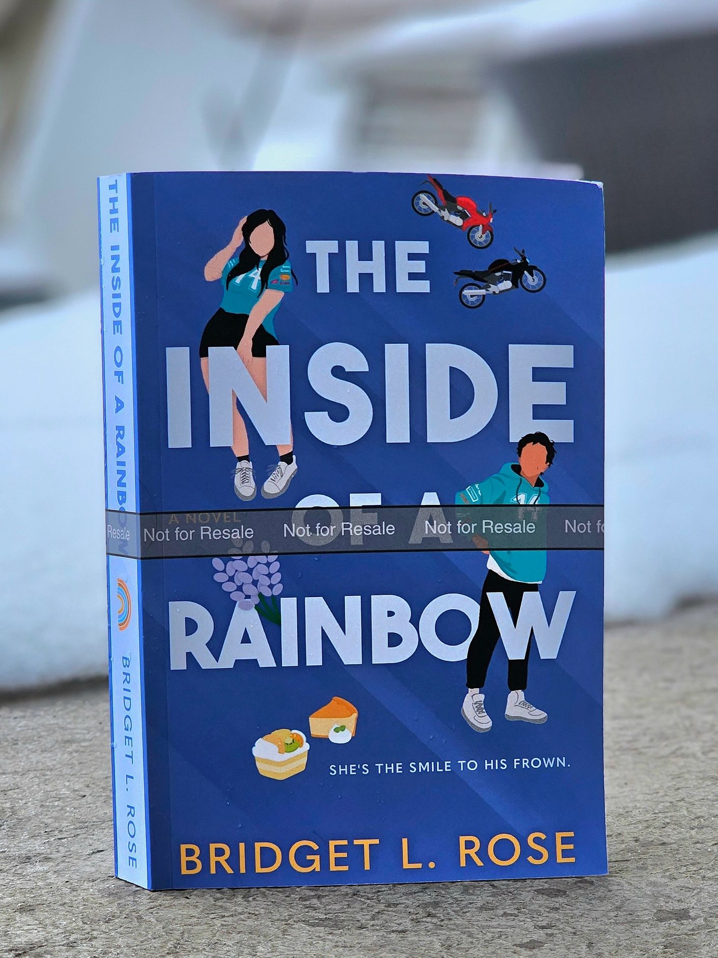 Bridget L. Rose's newest book The Inside of a Rainbow standing in front of snow. 