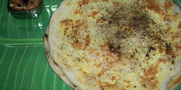 South Indian uttapam served on a banana leaf with chutney.