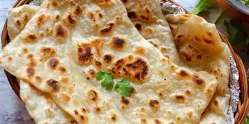 Golden brown flatbreads served in a basket.
