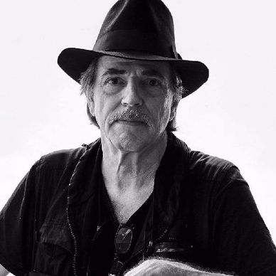 Black and white portrait of an older man wearing a hat and dark clothing.