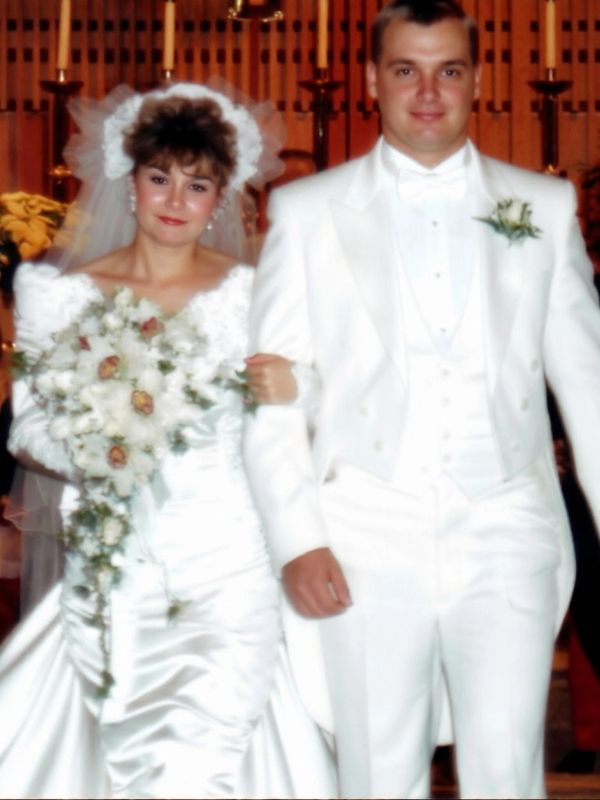 Bride and groom in white wedding attire.