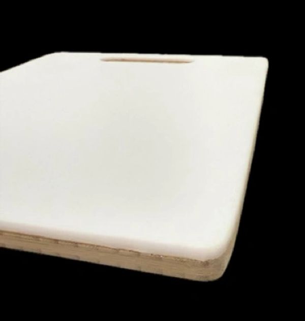 White wooden cutting board with a handle slot, isolated on black background.