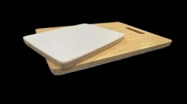 A wooden cutting board with a white ceramic insert on top.