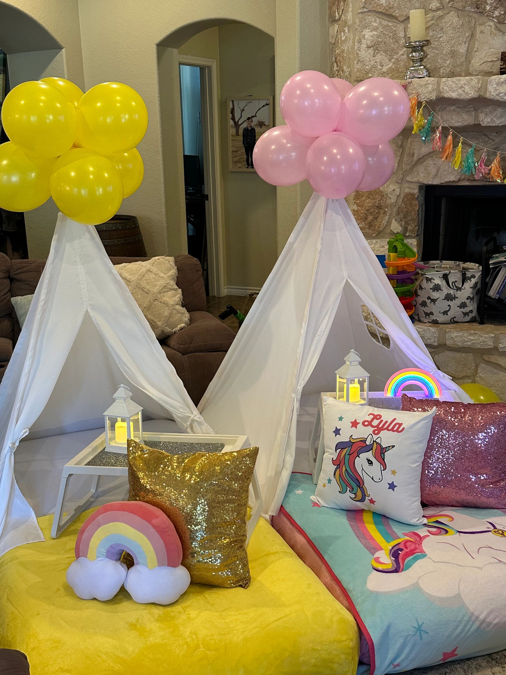 Kids' play tents decorated with balloons and colorful pillows.