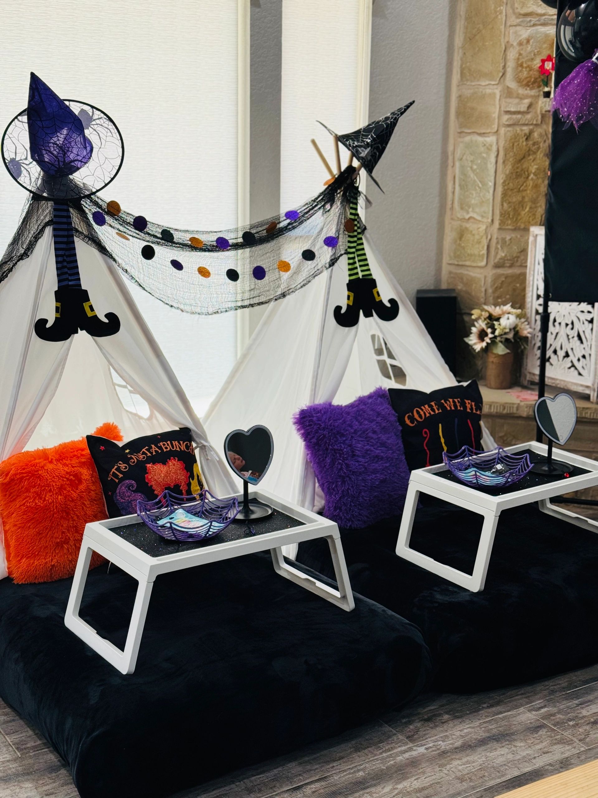 Cozy Halloween-themed teepee setup with colorful pillows and festive decorations.