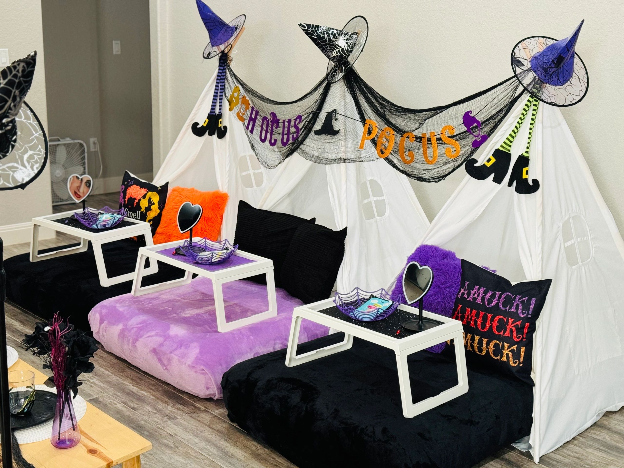Halloween-themed indoor setup with witch hats, pillows, and tents.