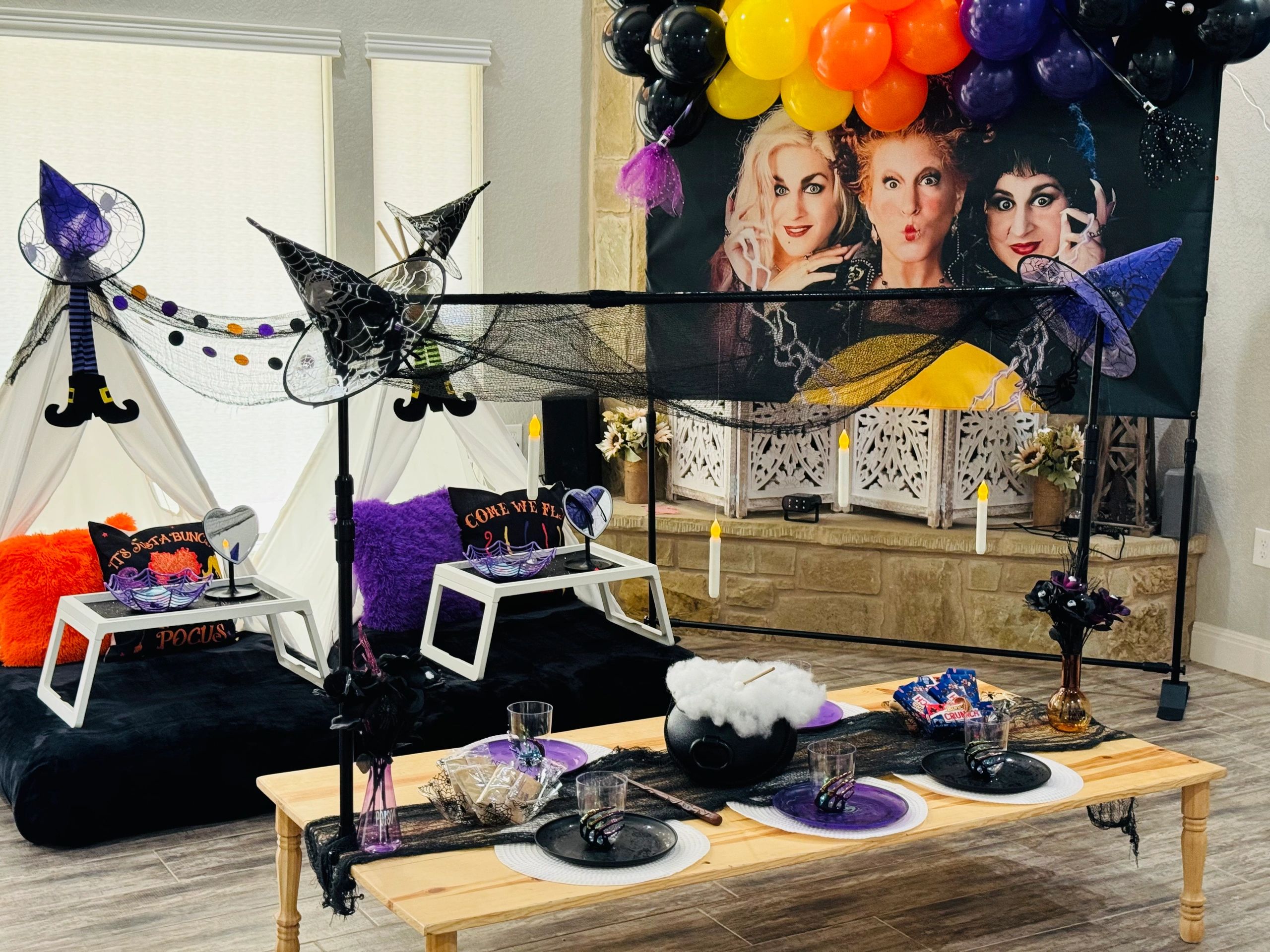 Halloween-themed room with witch decorations and a themed backdrop.