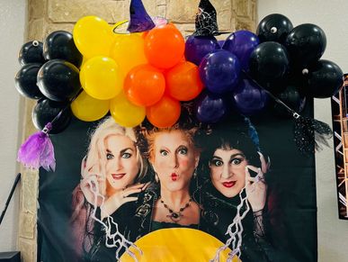 Colorful Halloween balloon decoration with witches and magical theme.