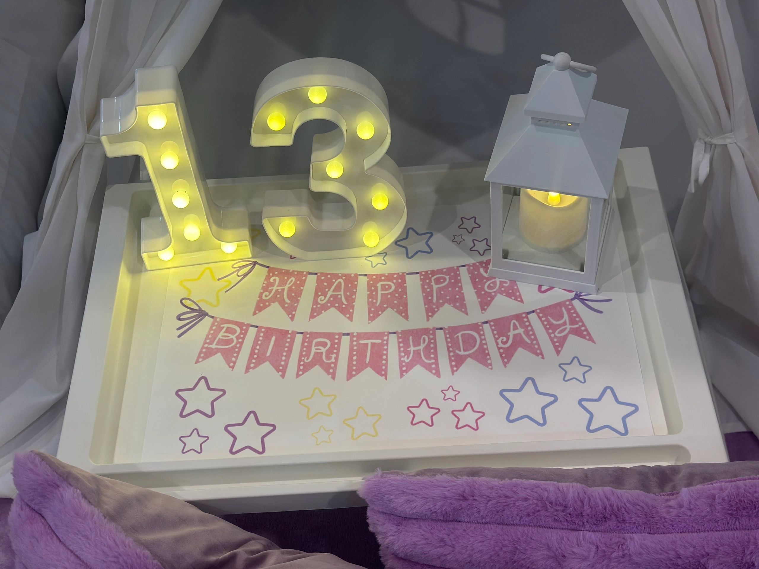 Decorative lit numbers 13 and a lantern on a birthday tray.