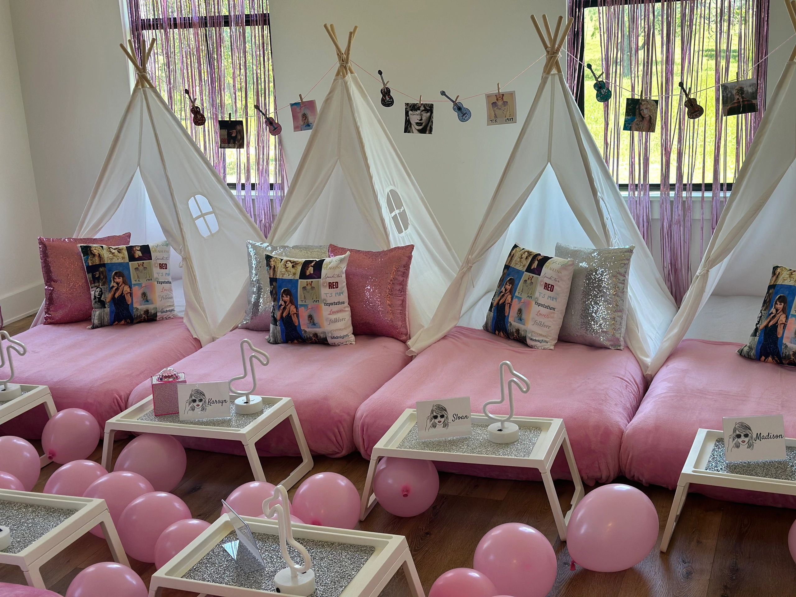 Cozy pink indoor tents with pillows and balloons for a fun sleepover party.