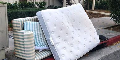 mattress and couch sitting outside on curb, junk