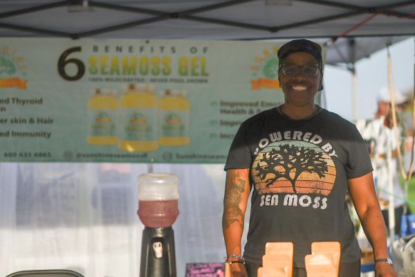 Woman at a booth promoting sea moss gel benefits.
