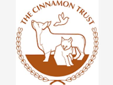 Logo of The Cinnamon Trust featuring a dog, a cat, and a bird within a laurel wreath.