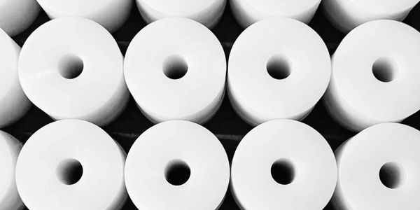 Stack of white cylindrical objects with central holes.