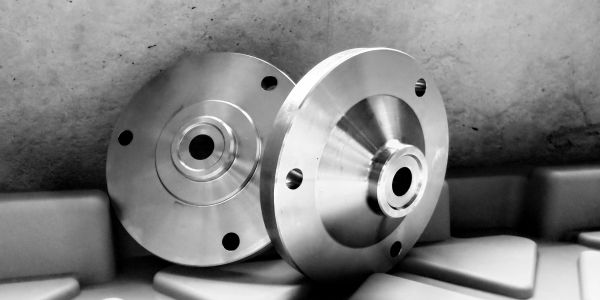 Two round metallic flanges resting on industrial parts.