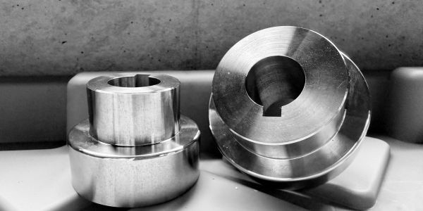 Two polished metal parts with central holes.