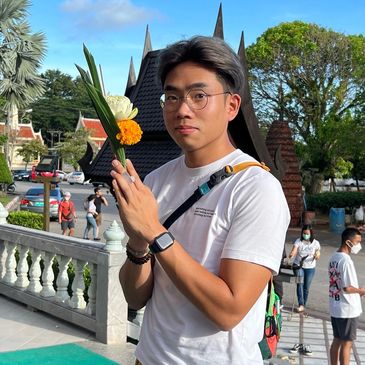 Nolan with hands in prayer position in Thailand