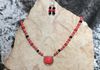 Red howlite beads  and black lava beads. Red howlite and silver metal pendant. Length 25.5 in. Item #19-2-2. Price $20.00