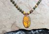 Close up of magnificent bumblebee jasper stone with copper wrapped Tree of Life