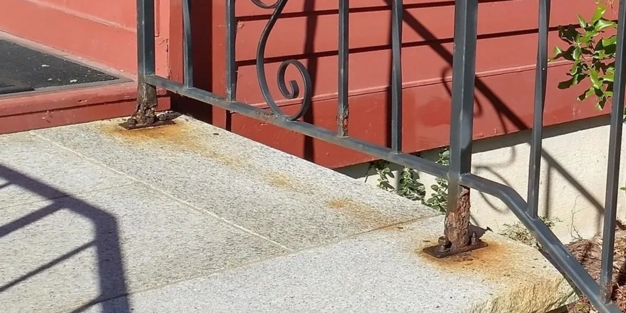 Photo of a railing with rusted out feet