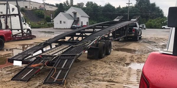 Photo of a car hauler trailer with Ramps getting welded on the back.