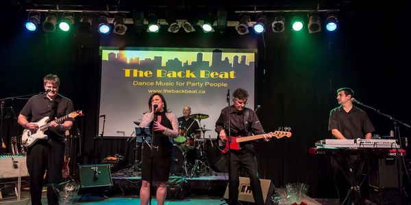 Band performing on stage under colorful lights.