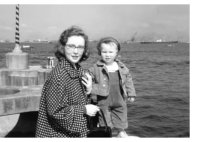 Black and white photo of a woman with a child by the waterfront.