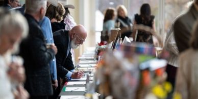 People browsing and signing at a charity auction event.