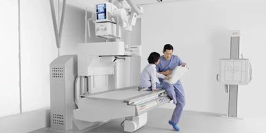 Two medical professionals discussing near radiology equipment.