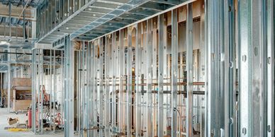 Interior construction site with metal framing and exposed ceiling.
