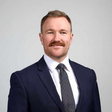 Professional man in suit and tie with mustache.