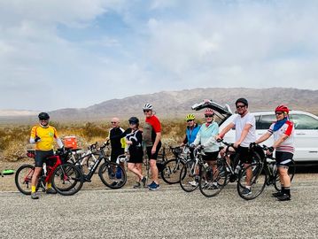 Cyclists taking a break in a desert area.
