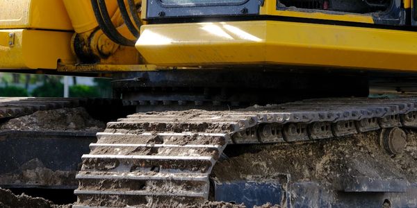 Close-up of a muddy excavator track.