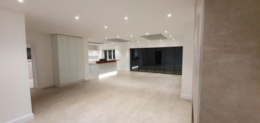 luxury open plan living room and kitchen in white with large grey floor tiles
